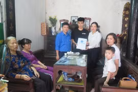 Đại diện Bảo hiểm Xã hội Việt Nam tặng quà cho hai con chị Hà. (Ảnh:PV/Vietnam+)