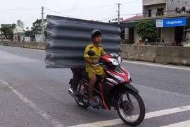 Người dân mua tấm lợp fibro ximăng. (Nguồn: TTXVN)