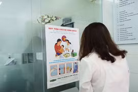 Người dân đọc thông tin tuyên truyền phòng chống bệnh viêm gan. (Ảnh: T.G/Vietnam+)