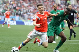 Pha tranh bóng quyết liệt giữa Aleksandr Golovin (trái) của Nga và Osama Hawsawi của Saudi Arabia Saudi trong trận đấu khai mạc FIFA World Cup 2018 diễn ra ngày 14/6. (Ảnh: THX/TTXVN)