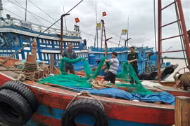 Cán bộ Đồn Biên phòng Sầm Sơn giúp ngư dân phường Quảng Tiến, thành phố Sầm Sơn, tỉnh Thanh Hóa, cất ngư lưới cụ, phòng chống bão. (Ảnh: Nguyễn Nam/TTXVN) 