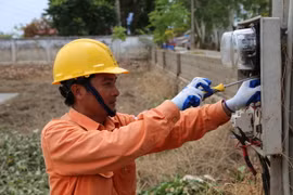 Nhân viên Công ty Điện lực huyện Chương Mỹ lắp đặt thay mới công tơ cho một số hộ dân có công tơ bị ngập nước, hư hỏng tại xã Nam Phương Tiến, huyện Chương Mỹ, Hà Nội. (Ảnh Mạnh Khánh/TTXVN)