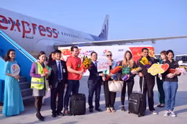 Tặng hoa chúc mừng những vị khách quốc tế đầu tiên đến "xông đất" Đà Nẵng bằng đường hàng không. (Ảnh: TTXVN phát)