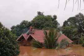 Người dân chờ cứu hộ tại vùng ngập lụt do sự cố vỡ đập thủy điện Xe Pian-Xe Namnoy ở Attapeu ngày 24/7. (Ảnh: THX/TTXVN)