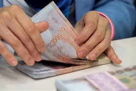 Kiểm tiền baht tại ngân hàng Krung Thai ở Bangkok, Thái Lan. (Nguồn: AFP/TTXVN)
