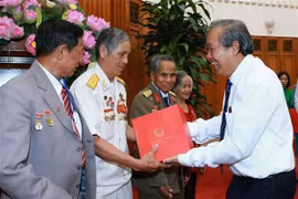 Phó Thủ tướng Thường trực Chính phủ Trương Hòa Bình tặng quà lưu niệm cho các đại biểu người có công tỉnh Kon Tum. (Ảnh: Doãn Tấn/TTXVN)