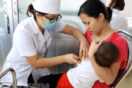 Nhân viên y tế tiêm phòng cho trẻ tại Hà Nội. (Ảnh: TTXVN)