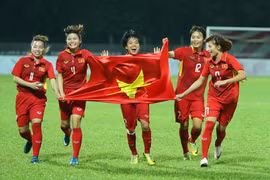 Các nữ cầu thủ Việt Nam vui mừng với tấm huy chương vàng giành được tại SEA Games 29. (Ảnh: Quốc Khánh/TTXVN)