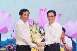 Phó Thủ tướng Vũ Đức Đam (bên phải) tặng hoa Chủ tịch Hội Nhà báo Việt Nam Thuận Hữu, chúc mừng những người làm báo trên cả nước. (Ảnh: Lâm Khánh/TTXVN)