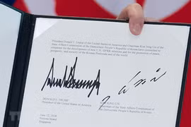 Văn kiện chung lưu lại chữ ký của Tổng thống Mỹ Donald Trump (trái) và của nhà lãnh đạo Triều Tiên Kim Jong-un (phải) tại Sentosa, Singapore ngày 12/6. (Nguồn: AFP/TTXVN)