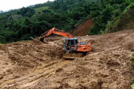 Máy múc được huy động tới giải tỏa điểm sạt lở nặng tại bản Pù Toong xã Pù Nhi, huyện Mường Lát. (Ảnh: Trịnh Duy Hưng/TTXVN)