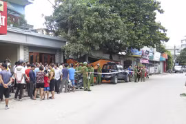 Lực lượng công an phong tỏa hiện trường và điều tra vụ án mạng. (Ảnh: Xuân Tư/TTXVN)