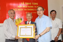 Bí thư Thành ủy Thành phố Hồ Chí Minh Nguyễn Thiện Nhân và lãnh đạo huyện Hóc Môn trao Huy hiệu 70 năm tuổi Đảng cho đảng viên Lê Văn Nghị. (Ảnh: Thanh Vũ/TTXVN)