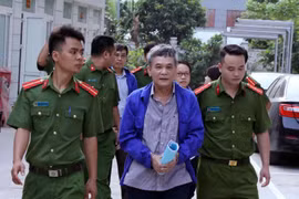 Cảnh sát dẫn giải bị cáo đến tòa. (Ảnh: Văn Điệp/TTXVN)