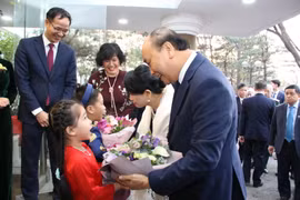 Các em thiếu nhi tặng hoa chào mừng Thủ tướng và Phu nhân tới thăm Đại sứ quán. (Ảnh: Hữu Tuyên/TTXVN)