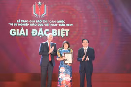 Bộ trưởng Bộ Giáo dục và Đào tạo Phùng Xuân Nhạ và giáo sư-tiến sỹ Raymond Gordon - đại diện Trường Đại học Anh Quốc Việt Nam trao giải Đặc biệt cho đại diện nhóm tác giả tác phẩm "Chuyện về những người thầy thắp lửa". (Ảnh: Thanh Tùng/TTXVN)