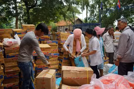 Tặng quà cho các gia đình khó khăn. (Ảnh: Trần Long-Minh Hưng/Vietnam+)