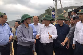 Phó Thủ tướng Trịnh Đình Dũng trao đổi với Chủ tịch Ủy ban Nhân dân tỉnh Bình Định về công tác ứng phó với bão số 6 tại xã Nhơn Hải, thành phố Quy Nhơn. (Ảnh: Nguyên Linh/TTXVN)