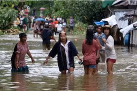 Người dân lội qua một con đường bị ngập lụt ở một ngôi làng ở Borongan, phía đông Samar, miền trung Philippines. (Nguồn: AFP)