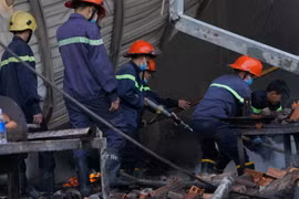 Lực lượng chức năng tích cực dập lửa. (Ảnh: Nguyễn Văn Việt/TTXVN)