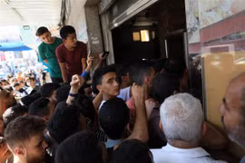 Người dân xếp hàng chờ nhận thức ăn cứu trợ tại Dải Gaza. (Ảnh: THX/TTXVN)