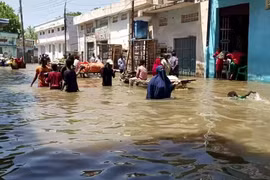Người dân lội qua một con phố ngập lụt ở Beledweyne, miền Trung Somalia trong trận lụt hồi tháng 5/2020. (Nguồn: AP)