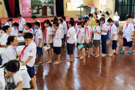 Cán bộ y tế quận Hoàng Mai phối hợp cùng các cán bộ y tế trên địa bàn khám sức khỏe định kỳ cho học sinh.(Nguồn: Cổng thông tin điện tử chính phủ)