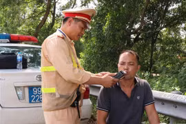 Lực lượng Cảnh sát giao thông tỉnh Bắc Ninh tiến hành kiểm tra nồng độ cồn trong người của người tham gia giao thông. (Ảnh: Thanh Thương/TTXVN)