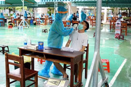 Lấy mẫu sinh phẩm cho người dân vùng có nguy cơ cao tại Đà Nẵng để xét nghiệm SARS-CoV-2. (Ảnh: TTXVN phát)