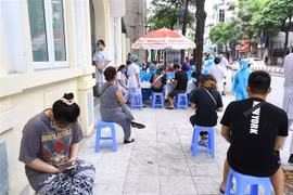 Người về từ Đà Nẵng chờ xét nghiệm nhanh tại phường Bách Khoa và phường Cầu Dền (quận Hai Bà Trưng,Hà Nội) sáng 1/8. (Ảnh: Minh Quyết/TTXVN)