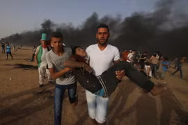 Chuyển nạn nhân bị thương trong cuộc xung đột giữa người biểu tình Palestine và binh sĩ Israel tại biên giới Gaza-Israel ngày 25/5. (Nguồn: THX/TTXVN)