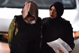 Cảnh sát áp giải Đoàn Thị Hương (trái) tại Tòa thượng thẩm Shah Alam, ngoại ô Kuala Lumpur, Malaysia ngày 16/8. (Ảnh: AFP/TTXVN)