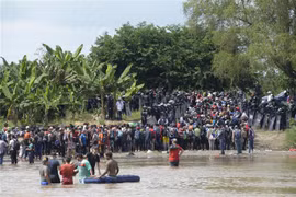 Người di cư băng qua sông Suchiate từ Ciudad Tecun Uman (Guatemala) để tới Ciudad Hidalgo (Mexico) trong hành trình đến Mỹ, ngày 29/10/2018. (Ảnh: AFP/TTXVN)