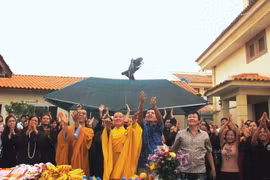 Đại sứ Nguyễn Mạnh Cường, Đại đức Thích Minh Huệ và bà con cộng đồng người Việt thực hiện nghi thức thả chim phóng sinh. (Ảnh: TTXVN)