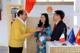 Khách tham quan trao đổi về cà phê với đại diện Thương vụ Việt Nam. (Ảnh: Ngự Bình/TTXVN)