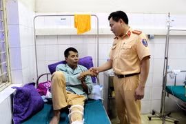 Lãnh đạo Phòng Cảnh sát giao thông Công an tỉnh Điện Biên thăm, động viên trung úy Cà Văn Mạnh tại Bệnh viện Đa khoa tỉnh Điện Biên, sáng ngày 8/6/2018. (Ảnh: Nguyễn Xuân Tiến/TTXVN)
