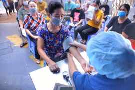 Khám sàng lọc cho người dân trước khi tiêm chủng. (Ảnh: Tuấn Đức/TTXVN)