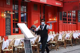 Nhân viên phục vụ thực khách tại một nhà hàng ở Paris, Pháp ngày 28/10/2020. (Ảnh: THX/TTXVN)
