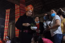 Thầy mo vẩy nước để làm phép, tượng trưng cho việc làm mát nhà trong nghi lễ cùng tên. (Ảnh: Minh Anh/Vietnam+)