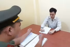 Đối tượng Trần Khắc Đức (giữa) tại cơ quan công an. (Ảnh: TTXVN phát)