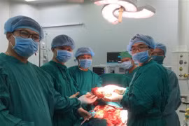 Các bác sỹ lấy khối u khỏi cơ thể bệnh nhân. (Ảnh: Ánh Tuyết/TTXVN)