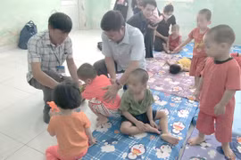 Ông Lê Văn Thinh, Giám đốc Sở Lao động-Thương binh và Xã hội Thành phố Hồ Chí Minh thăm các trẻ em được đưa về Cơ sở nuôi dưỡng bảo trợ trẻ em Tam Bình. (Ảnh: Thanh Vũ/TTXVN)