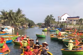 Du khách ngồi trên các chiếc thuyền thúng do người dân địa phương chèo để tận hưởng vẻ đẹp sông nước. (Ảnh: Thúy Lan/Vietnam+)