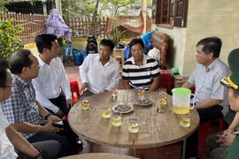 Lãnh đạo tỉnh Quảng Bình thăm hỏi các ngư dân được cứu sống trở về địa phương. (Ảnh: TTXVN phát)