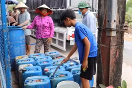 Người dân đến lấy nước tại điểm cấp nước tại ấp Pháo Đài, xã Phú Tân. (Ảnh: Minh Trí/TTXVN)
