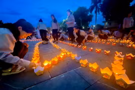 Các phật tử thắp nến trong Đại lễ cầu siêu tri ân Anh hùng Liệt sỹ tại Quảng trường Giải phóng, thị xã Quảng Trị. (Ảnh: Nguyên Linh/TTXVN)