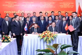 Thượng tướng Võ Minh Lương (phải), Thứ trưởng Bộ Quốc phòng, Trưởng ban Ban Công tác đặc biệt Chính phủ Việt Nam và Thượng tướng Thongloi Silivong (trái), Thứ trưởng Bộ Quốc phòng, Chủ nhiệm Tổng cục Chính trị QĐND Lào, Trưởng ban Ban Công tác đặc biệt Chính phủ Lào, ký Biên bản Kỳ họp. (Ảnh: Xuân Khu/TTXVN)