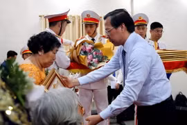 Chủ tịch UBND Thành phố Hồ Chí Minh Phan Văn Mãi truy tặng danh hiệu Mẹ Việt Nam Anh hùng cho 7 mẹ tại buổi lễ. (Ảnh: Thanh Vũ/TTXVN)