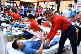 Ông Lê Văn Hậu, Phó trưởng Ban chỉ đạo vận động hiến máu tình nguyện, Chủ tịch Hội Chữ thập đỏ tỉnh Bà Rịa-Vũng Tàu tặng hoa tri ân tình nguyện viên tham gia hiến máu cho ngày hội chính. (Ảnh: Huỳnh Sơn/TTXVN)