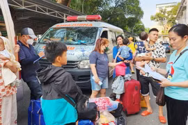 Thân nhân và bệnh nhi chờ đợi để lên chuyến xe 0 đồng về quê đón Tết. (Ảnh: Đinh Hằng/TTXVN)
